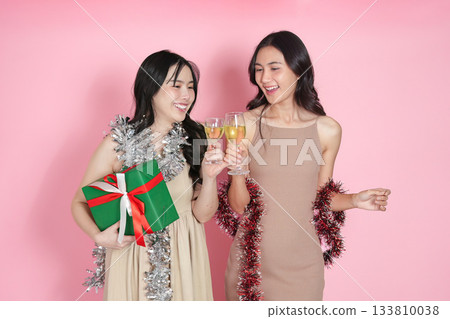 Celebration. Two friends toasting with champagne glasses against a pink background. Celebration. Two friends toasting with champagne glasses against a pink background. 133810038