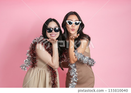 Fun. Friends blowing kisses and posing with sunglasses for a playful photo. 133810040