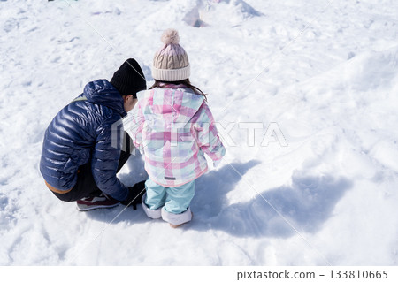父母和孩子們在雪地裡玩耍 父母和孩子們在雪地裡玩耍 133810665