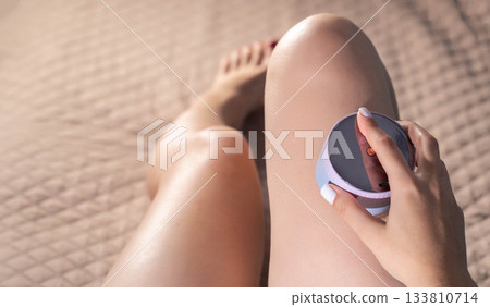 The girl gives herself an anti-cellulite relaxing massage with a portable vacuum massager, flabbiness and elasticity of the skin. Copy space for text The girl gives herself an anti-cellulite relaxing massage with a portable vacuum massager, flabbiness and elasticity of the skin. Copy space for text 133810714