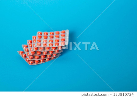 A stack of pills on a blue background for toothache and herpes. Copy space for text, metabolism A stack of pills on a blue background for toothache and herpes. Copy space for text, metabolism 133810724