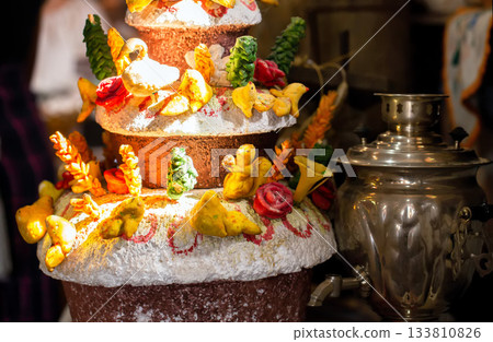 A homemade wedding loaf in the village with decorations against a backdrop of a samovar. Village baking, close-up A homemade wedding loaf in the village with decorations against a backdrop of a samovar. Village baking, close-up 133810826