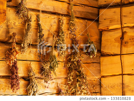 Medicinal herbs in a rustic herbalist's shop against a wooden log wall. Nettle, thyme, and fireweed. Herbal treatment Medicinal herbs in a rustic herbalist's shop against a wooden log wall. Nettle, thyme, and fireweed. Herbal treatment 133810828