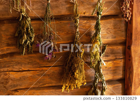 Medicinal herbs in a rustic herbalist's shop against a wooden log wall. Nettle, thyme, and fireweed. Herbal treatment Medicinal herbs in a rustic herbalist's shop against a wooden log wall. Nettle, thyme, and fireweed. Herbal treatment 133810829
