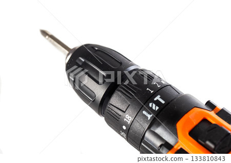 Cordless drill screwdriver with metal bit and torque adjustment ring against clean white background, power tool detail for construction and DIY work. Cordless drill screwdriver with metal bit and torque adjustment ring against clean white background, power tool detail for construction and DIY work. 133810843