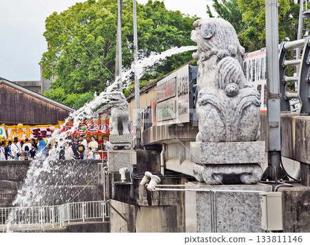 在福岡縣田川市舉行的風寺八幡神社渡河祭上,一隻守護犬正在噴水。 在福岡縣田川市舉行的風寺八幡神社渡河祭上,一隻守護犬正在噴水。 133811146