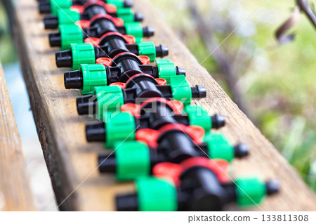 Multicolored plastic taps for assembling drip irrigation at the dacha, close-up Multicolored plastic taps for assembling drip irrigation at the dacha, close-up 133811308