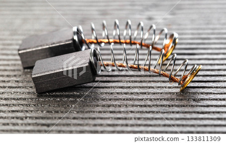 Electric motor brushes on gray background, macro, industry 133811309