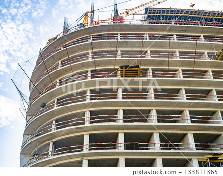 Construction of a modern high-rise building. Sides on the floors. Concrete frame of a building under construction. Construction in progress Construction of a modern high-rise building. Sides on the floors. Concrete frame of a building under construction. Construction in progress 133811365
