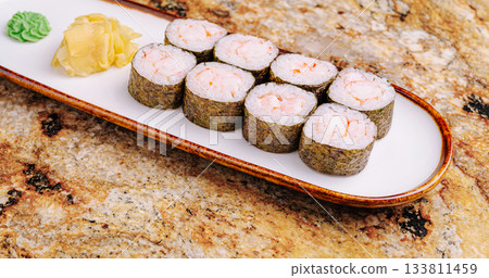 Fresh sushi rolls with wasabi and ginger on a stone countertop Fresh sushi rolls with wasabi and ginger on a stone countertop 133811459