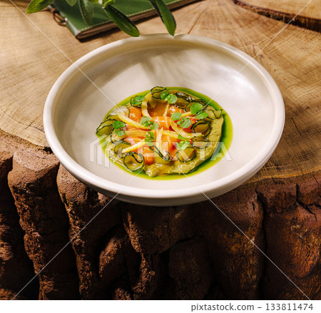 Delicious dish served on rustic wooden table in a cozy dining setting Delicious dish served on rustic wooden table in a cozy dining setting 133811474