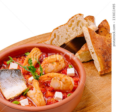 Delicious shrimp and fish stew served with crusty bread on a wooden board Delicious shrimp and fish stew served with crusty bread on a wooden board 133811495