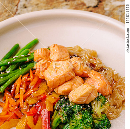 Healthy salmon dish with fresh vegetables in a clean setting Healthy salmon dish with fresh vegetables in a clean setting 133811516