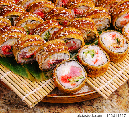 Delicious sushi rolls arranged beautifully on a wooden platter 133811517