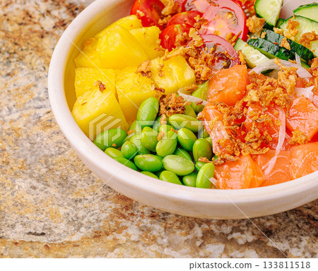 Fresh bowl of colorful ingredients with fruits and vegetables on a stone surface Fresh bowl of colorful ingredients with fruits and vegetables on a stone surface 133811518