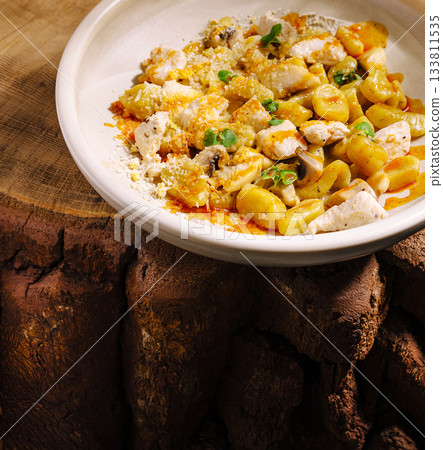 Delicious homemade pasta dish served on rustic wooden table Delicious homemade pasta dish served on rustic wooden table 133811535