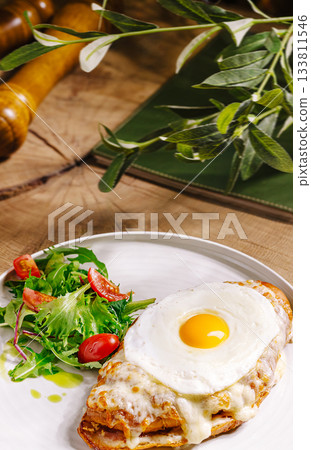 Delicious breakfast plate with fried egg and fresh salad on wooden table Delicious breakfast plate with fried egg and fresh salad on wooden table 133811546
