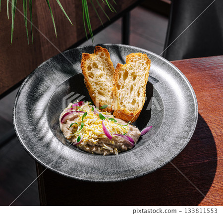 Delicious dish served with toasted bread in a modern dining setting 133811553