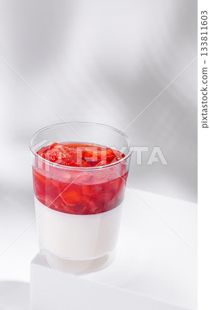 Delicious dessert with layered strawberry and cream in a clear cup 133811603