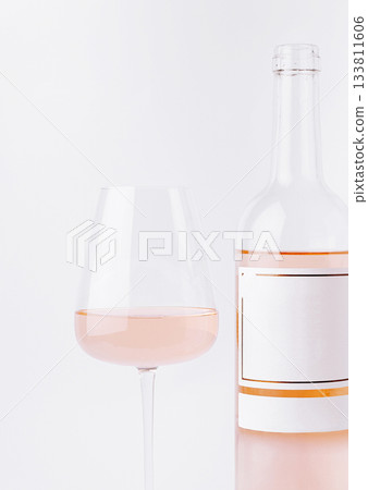 Enjoying a glass of rose wine with a bottle on a simple background Enjoying a glass of rose wine with a bottle on a simple background 133811606