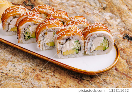 Delicious sushi rolls served on a simple white plate in a restaurant setting Delicious sushi rolls served on a simple white plate in a restaurant setting 133811632