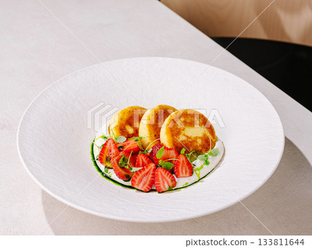 Delicious pancakes served with fresh strawberries and mint sauce 133811644