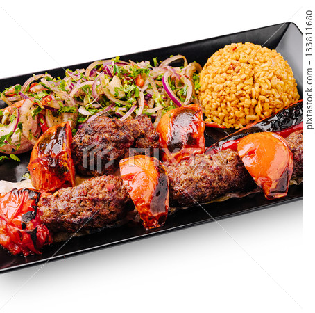Delicious kebab platter with rice and salad in a vibrant setting Delicious kebab platter with rice and salad in a vibrant setting 133811680