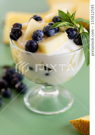 Dessert parfait of yogurt melon and blueberries on a green background 133812595