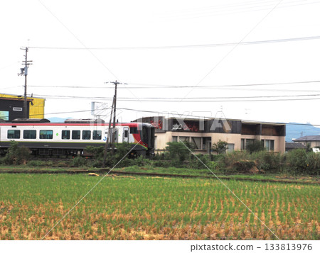 A limited express train (JR Shikoku 2700 series diesel railcar) running through the Kancho Plain in summer 133813976