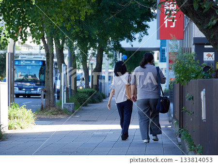 A female office worker walking to work in a busy downtown area in summer 133814053