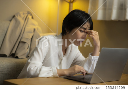 夜裡,一名女子在房間裡操作電腦。 夜裡,一名女子在房間裡操作電腦。 133814209
