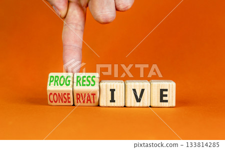 Progressive or conservative symbol. Businessman turns wooden cubes and changes word Conservative to Progressive. Beautiful orange background. Business progressive or conservative concept. Copy space. 133814285