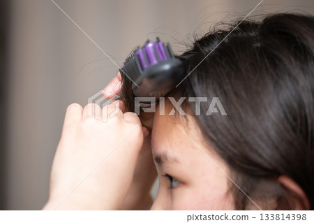 The hands of a girl setting her bangs 133814398