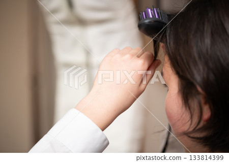 The hands of a girl setting her bangs 133814399