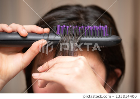 The hands of a girl setting her bangs 133814400