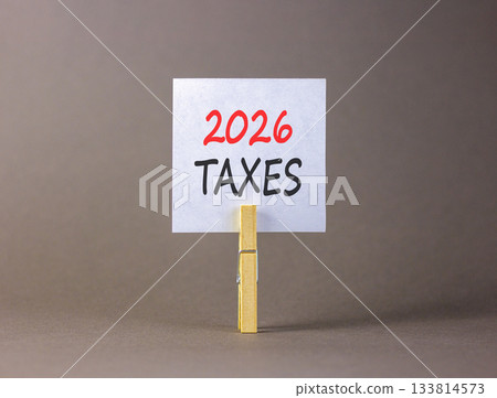 2026 taxes new year symbol. Concept words 2026 taxes on beautiful white paper on wooden clothespin. Beautiful grey background. Business and 2026 taxes new year concept. Copy space. 133814573