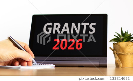 Grants 2026 symbol. Concept words Grants 2026 on beautiful black tablet screen. Beautiful white background. Businessman's hand. Business and grants 2026 concept. Copy space. 133814651