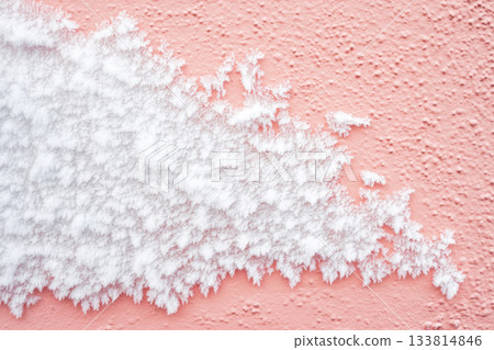 Beautiful frost covers part of a pink wall, showcasing unique patterns that glisten in the cold light of winter 133814846
