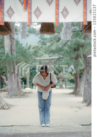 一位女子在神龕前祈禱。 133815137