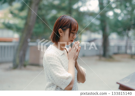 A woman praying at a shrine A woman praying at a shrine 133815140