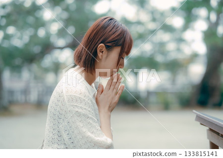 一位女子在神龕前祈禱。 一位女子在神龕前祈禱。 133815141