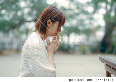 一位女子在神龕前祈禱。 133815143