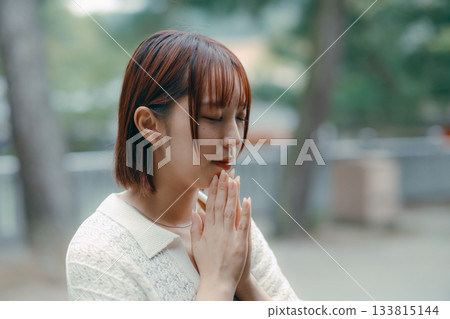 一位女子在神龕前祈禱。 133815144