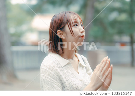 一位女子在神龕前祈禱。 133815147