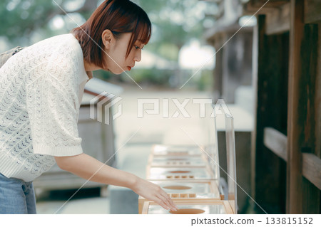 A woman praying at a shrine 133815152