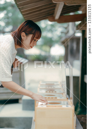 一位女子在神龕前祈禱。 133815155