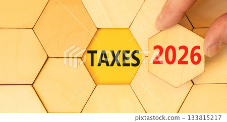 Taxes 2026 new year symbol. Concept words Taxes 2026 on beautiful wooden puzzles. Beautiful wooden puzzles background. Businessman's hand. Business and taxes 2026 new year concept. Copy space. 133815217