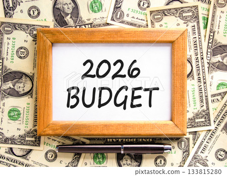 2026 Budget symbol. Concept words 2026 Budget on beautiful wooden picture frame. Beautiful dollar bills background. Black pen. Dollar bills. Business and 2026 budget concept. Copy space. 133815280