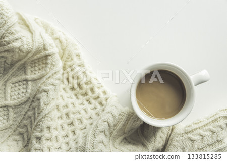 Winter image of a white background, a mug of cafe au lait, and cable knit 133815285