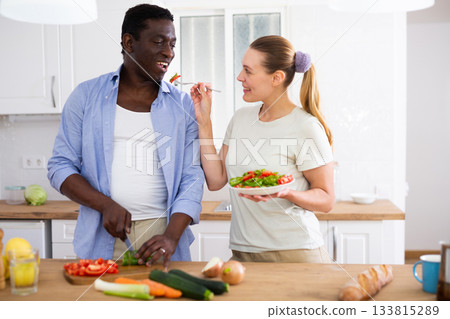 Happy biracial family couple cooking healthy vegetable dinner together Happy biracial family couple cooking healthy vegetable dinner together 133815289